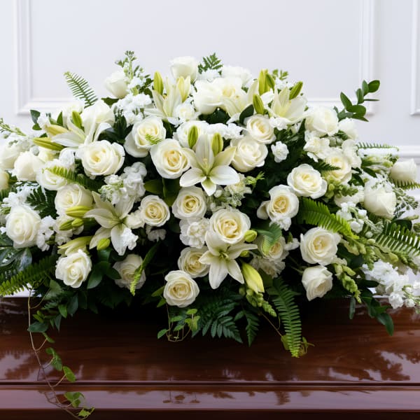 White floral casket spray with roses and lilies