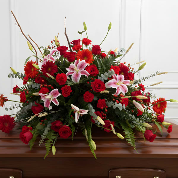 Large red and pink floral spray on a casket
