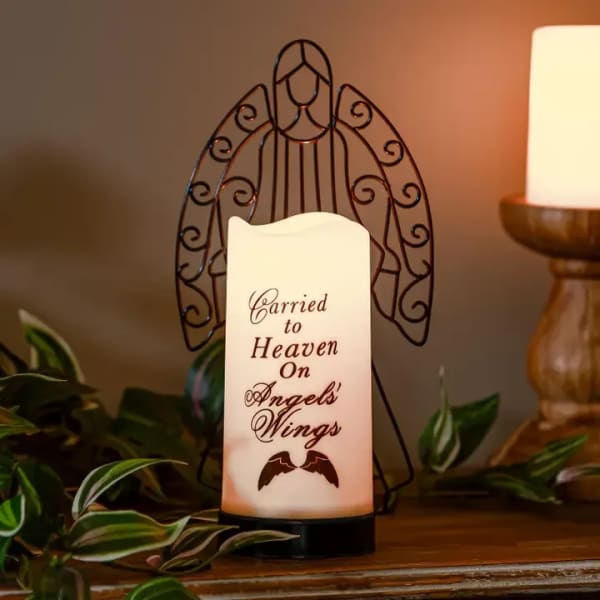 Memorial candle with angel wings and a sympathy message