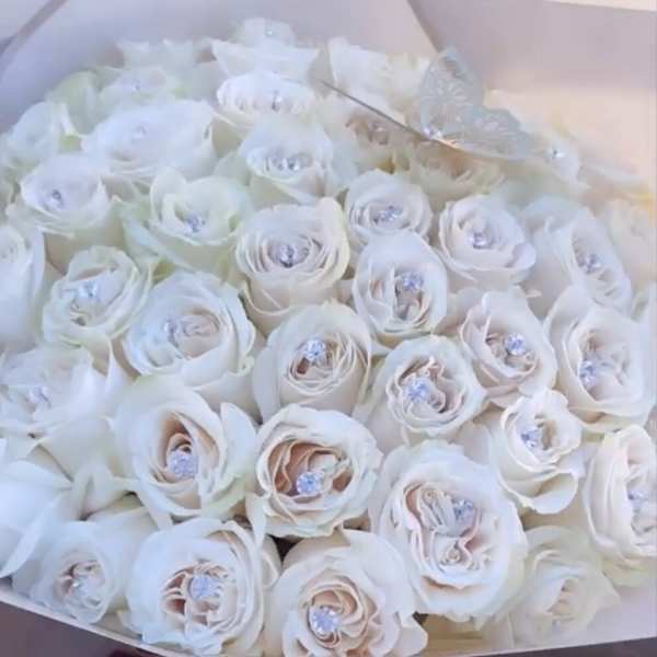 Bouquet of white roses in a pale box with a "50 roses" label