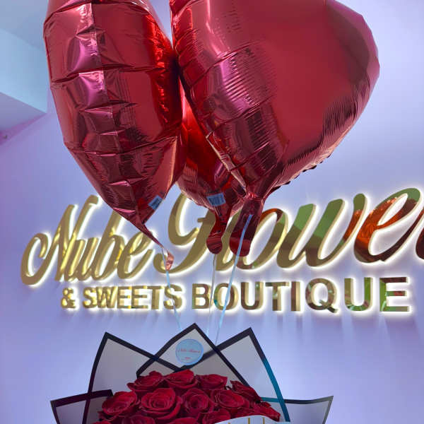 Bouquet of red roses with heart-shaped balloons and a birthday ribbon