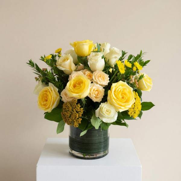 Yellow and white rose arrangement in a glass vase