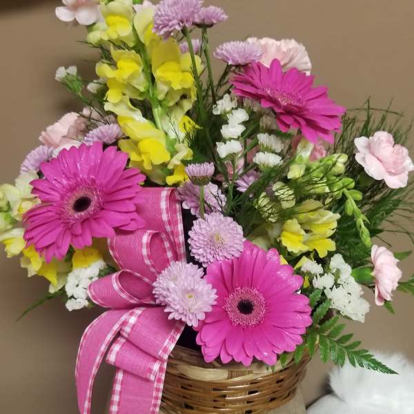 Basket arrangement with pink gerbera daisies and yellow snapdragons