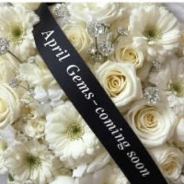 White roses and daisies with a black mourning ribbon