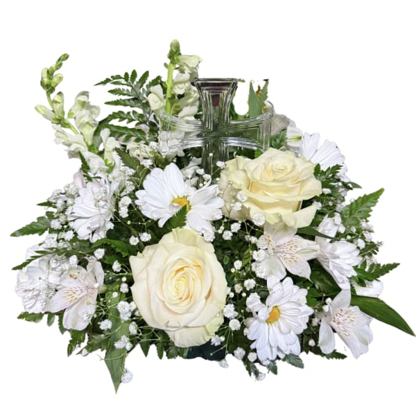White roses and daisies arranged around a clear glass cross