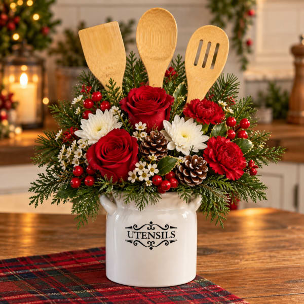 Holiday floral arrangement in a white utensil crock with wooden spoons
