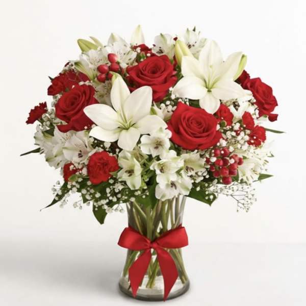 Red roses and white lilies in a glass vase with a red ribbon