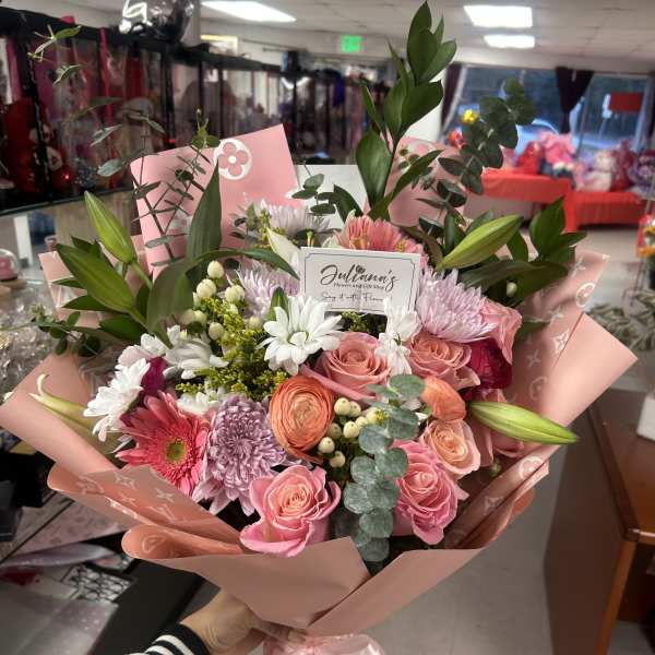 Pink and white mixed bouquet with roses and daisies wrapped in pink paper