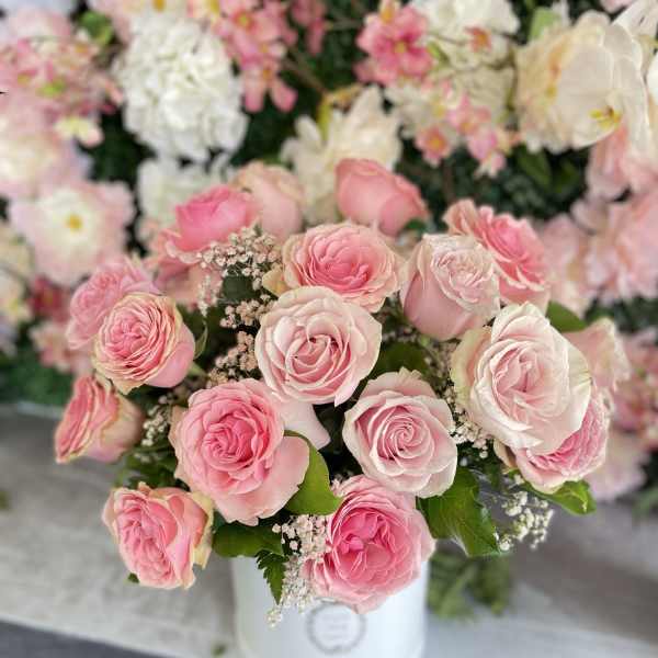 Pink and white roses arranged in a white vase