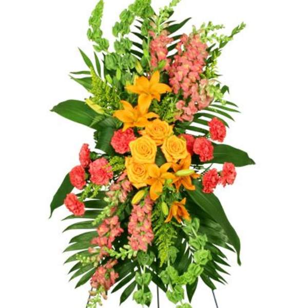 Tall standing floral spray with yellow lilies, roses, and pink blooms