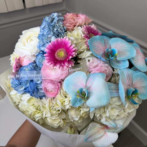 Bouquet of pastel flowers with blue orchids and pink daisies