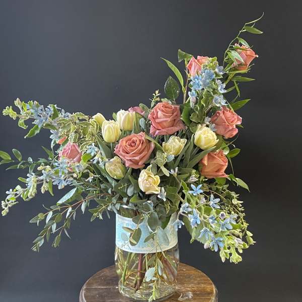 Mixed bouquet of pink roses and pale tulips in a glass vase