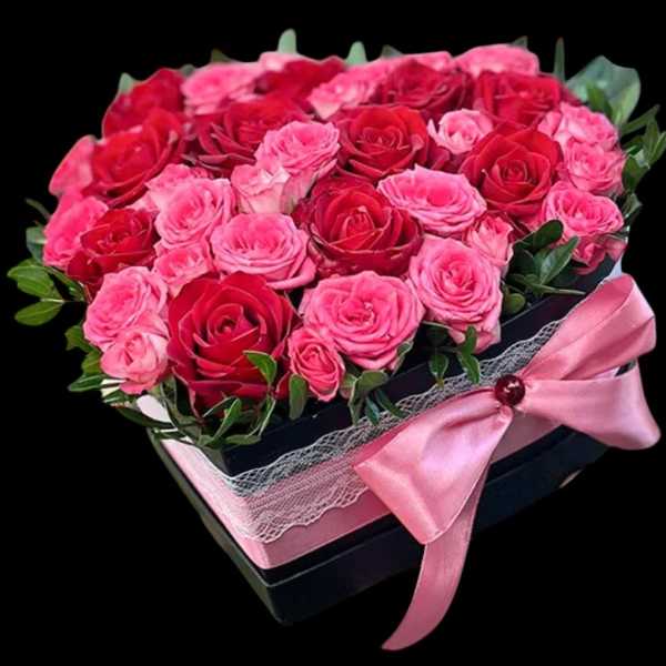 Pink and red roses in a black gift box with a pink ribbon
