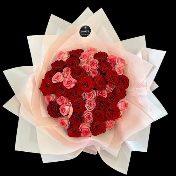 Bouquet of red and pink roses wrapped in pale paper