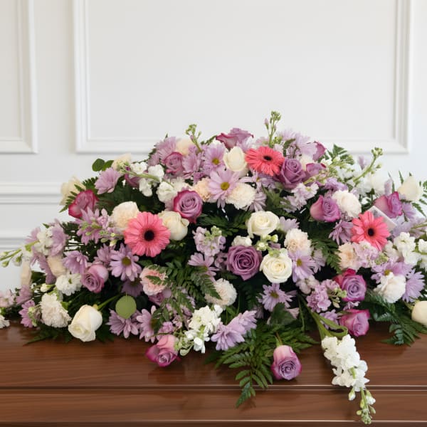 Large pastel floral casket spray with roses and daisies