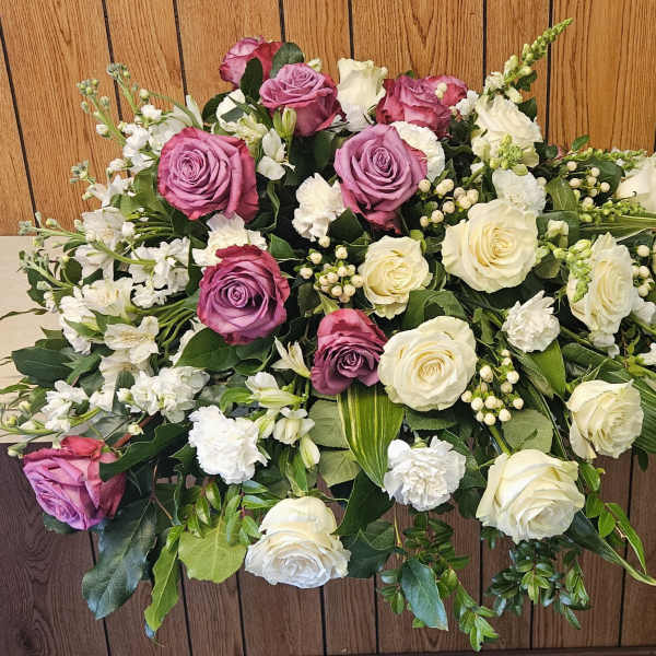 Casket spray with pink and white roses and mixed white flowers