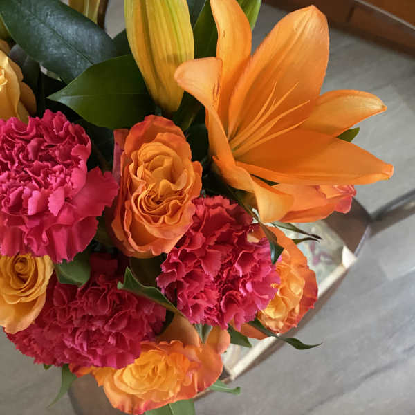 Bouquet of orange lilies and pink carnations with orange roses