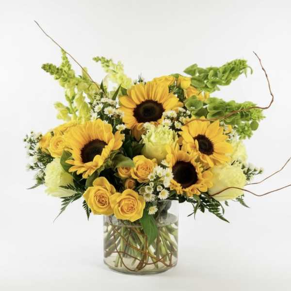 Sunflower and yellow rose bouquet in a clear glass vase