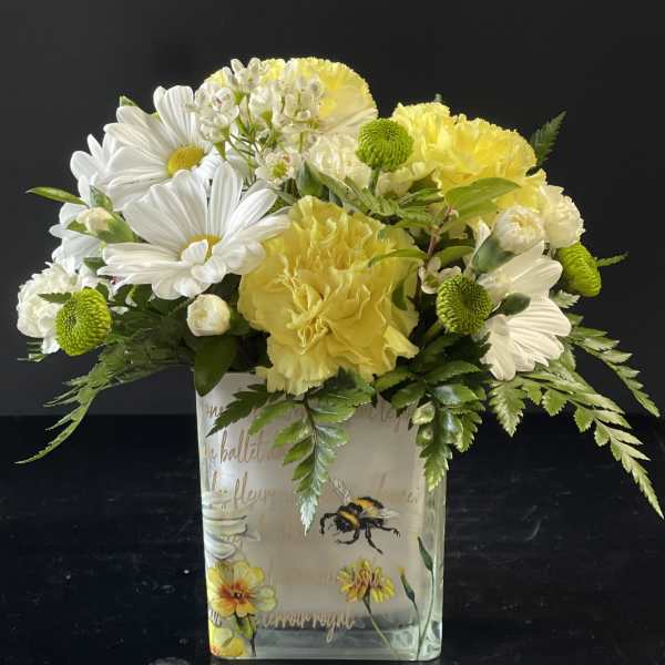 Yellow and white bouquet in a decorated glass vase