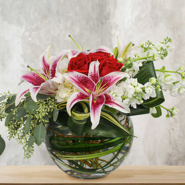 Bouquet of red roses and pink lilies in a glass vase
