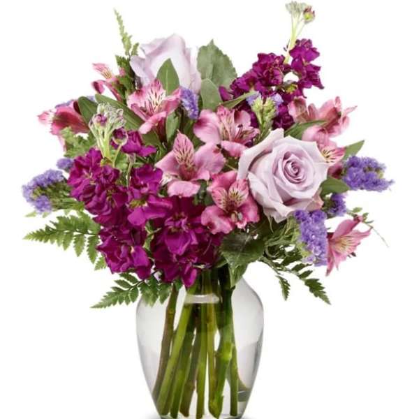 Bouquet of pink and purple flowers in a clear glass vase