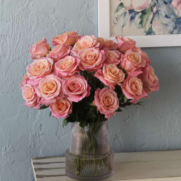 Pink and peach roses arranged in a ribbed glass vase