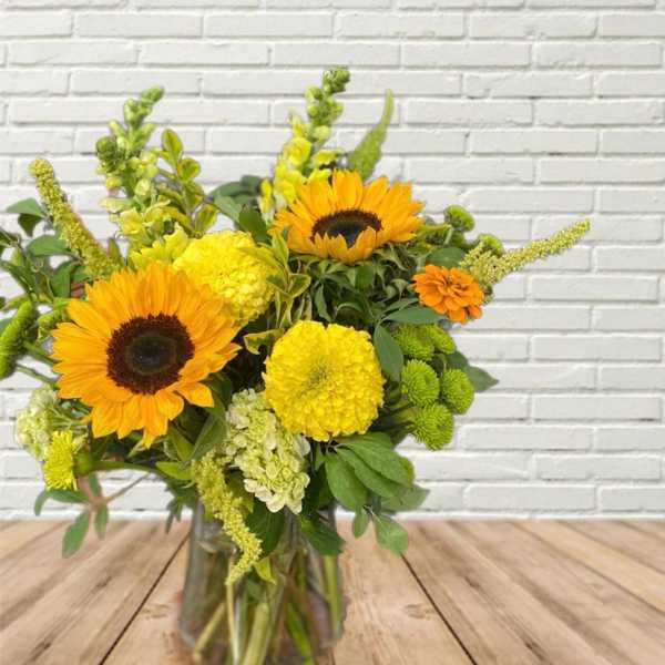 Sunflowers and yellow blooms in a glass vase