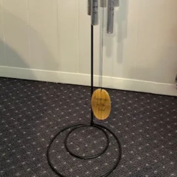 Hanging metal wind chime with silver tubes and a wooden top