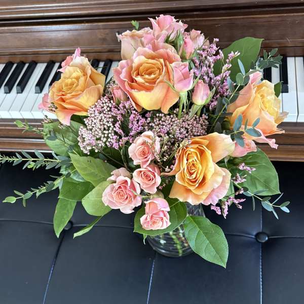 Bouquet of peach and pink roses in a glass vase