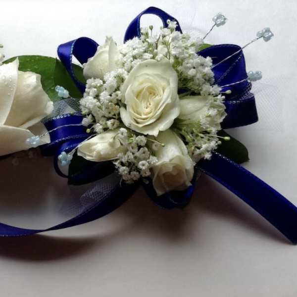 Two white rose boutonnieres with blue ribbon accents