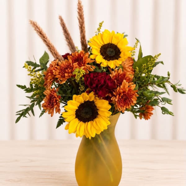 Sunflowers and orange chrysanthemums in a yellow vase