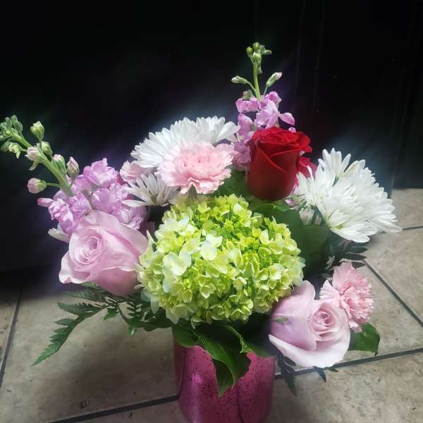 Pink and white mixed flower arrangement in a pink vase