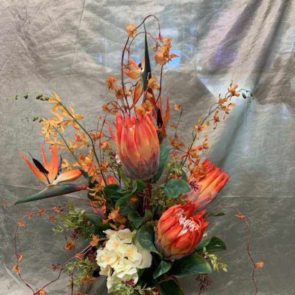 Orange tropical flowers arranged in a glass vase