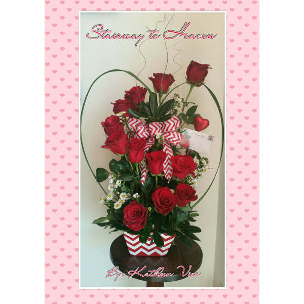 Tall arrangement of red roses in a chevron-patterned container with a heart accent