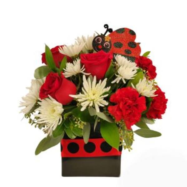 Red roses and white daisies in a ladybug-themed box