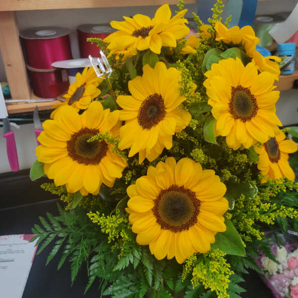 Bouquet of bright yellow sunflowers with green filler