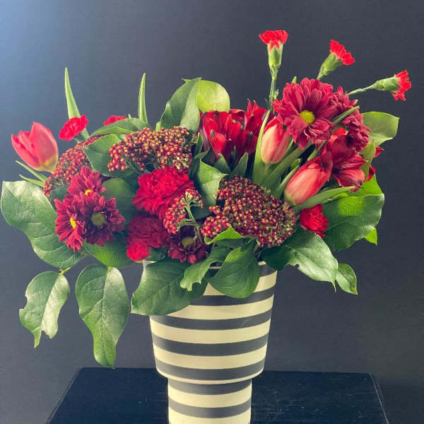 Red and pink mixed bouquet in a striped vase