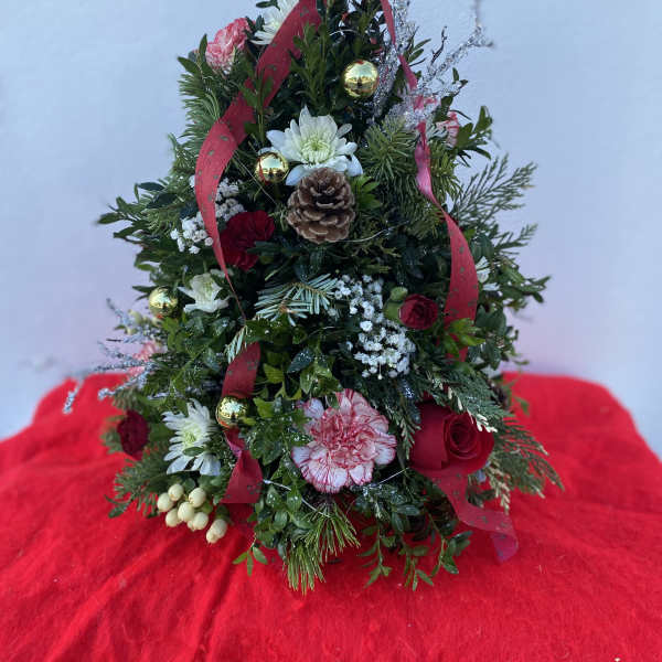 Christmas tree-shaped floral arrangement with red ribbon and ornaments