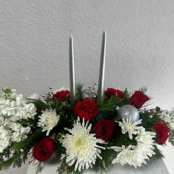 Red and white floral centerpiece with two silver taper candles