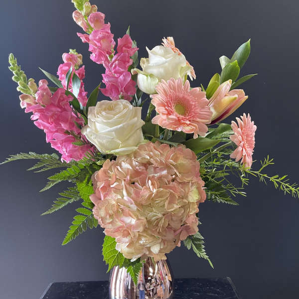Arrangement of pink and white flowers with hydrangea and roses in a metallic rose-gold vase