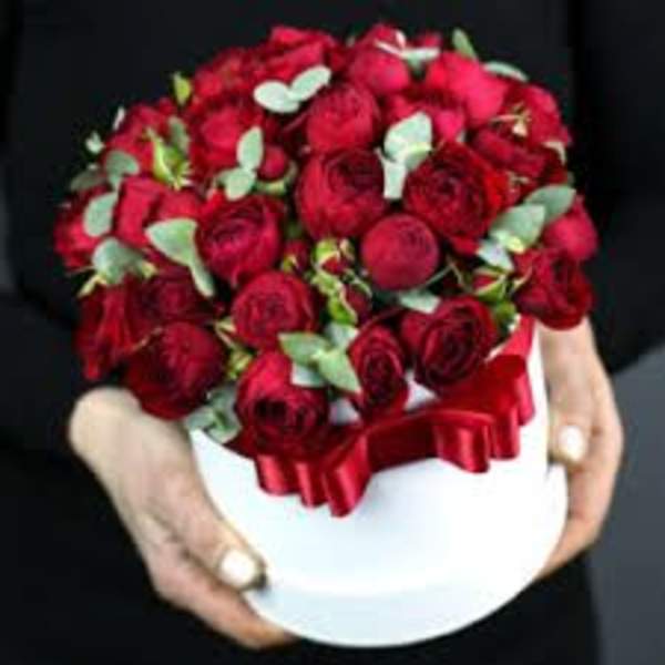 Red rose bouquet in a white hatbox with a red ribbon