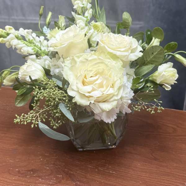 Cream rose bouquet in a clear glass vase