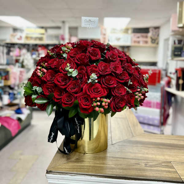 Large dome bouquet of red roses in a gold vase