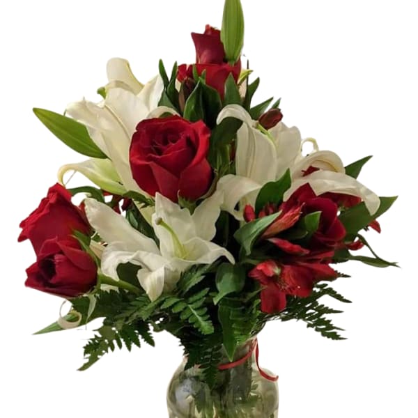 Red roses and white lilies arranged in a glass vase