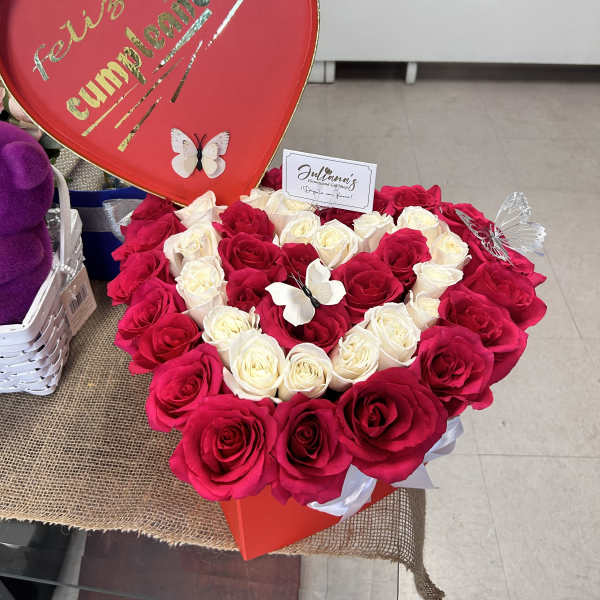Heart-shaped rose arrangement with a red "Feliz cumpleaños" sign
