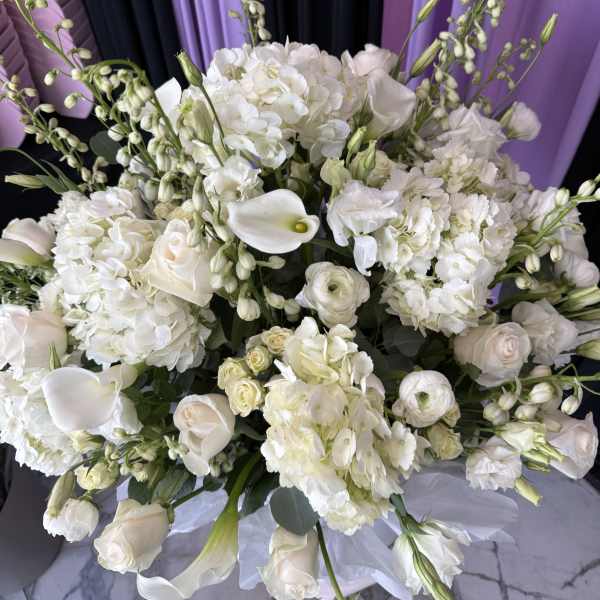 White floral bouquet with calla lilies, roses, and hydrangeas