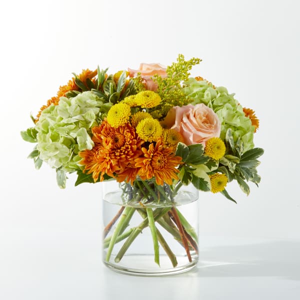 Mixed orange and yellow flowers in a clear glass vase