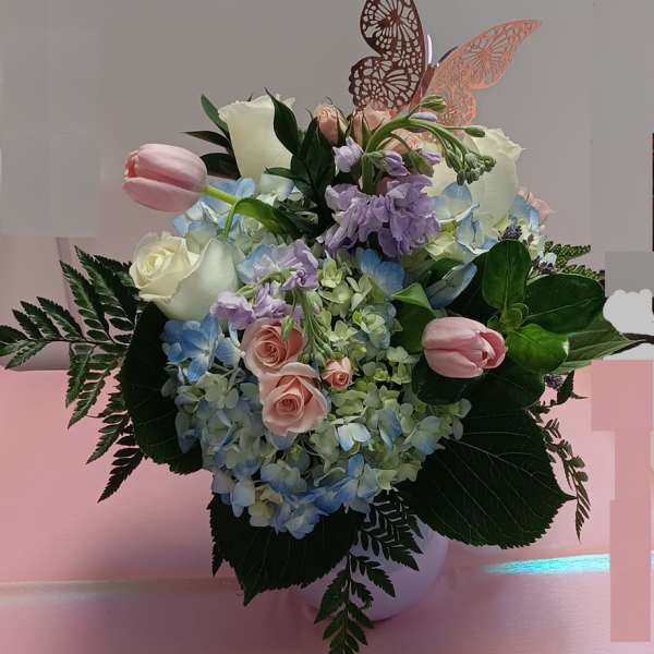 Pastel flower arrangement with roses, hydrangeas, and tulips in a vase
