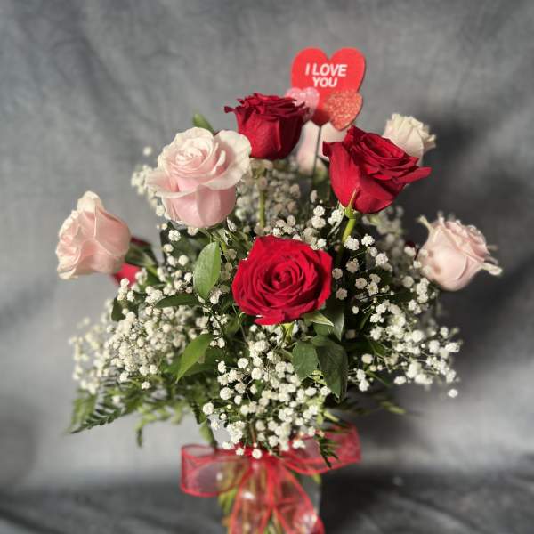 Bouquet of red and pale pink roses with a heart topper and red ribbon