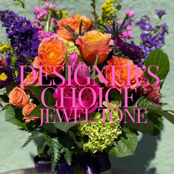 Bright jewel-tone bouquet with orange and pink roses, purple blooms, and green hydrangea.